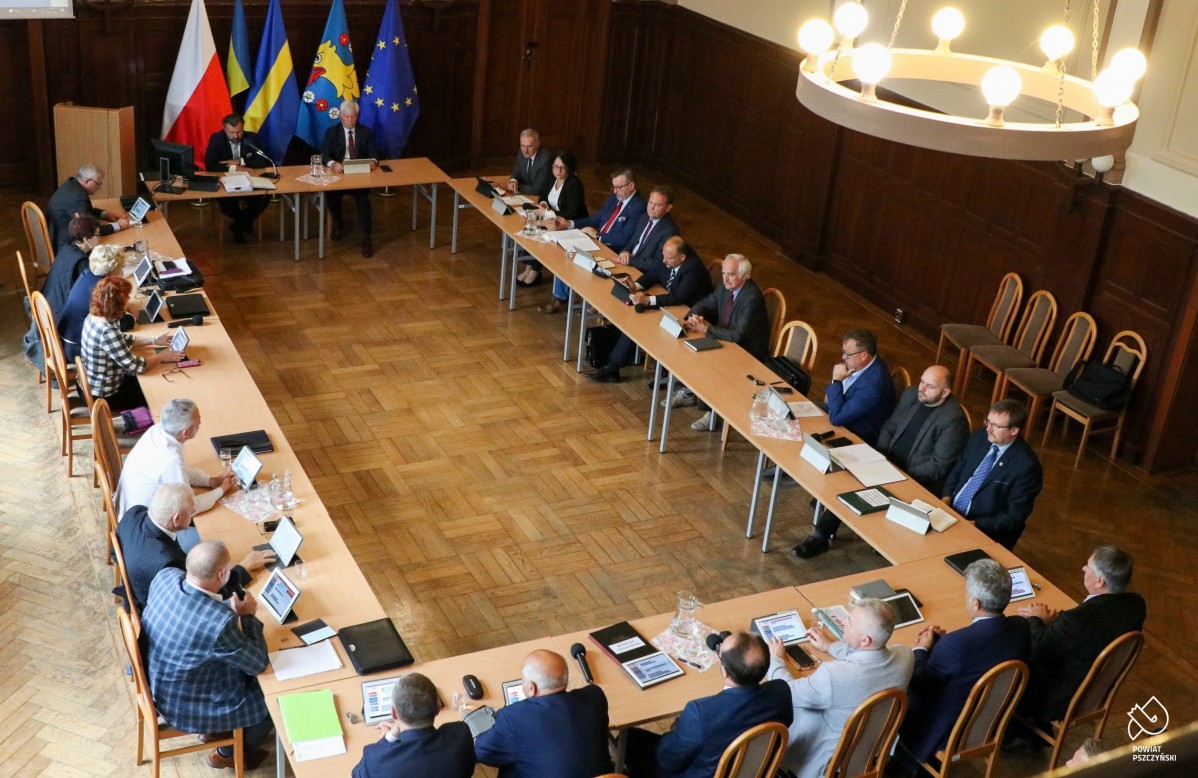 Za stołami w sali sesyjnej siedzą radni. Trwa sesja.