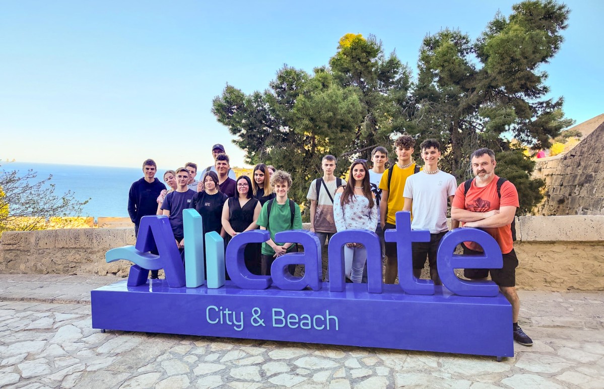 Uczniowie z opiekunami stoją przy napisie Alicante.