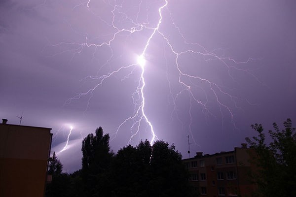 Piorun na niebie nad budynkami.