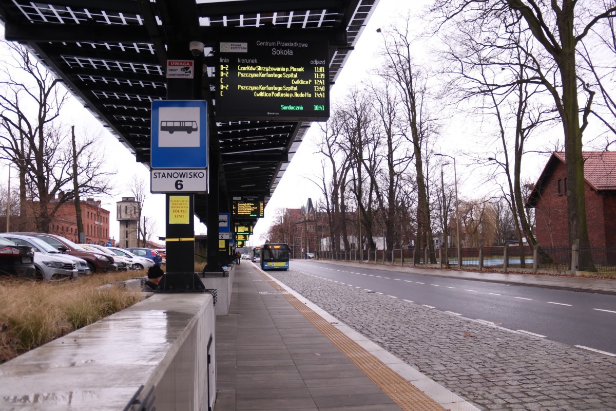 Przystanek autobusowy na centrum przesiadkowym. W oddali nadjeżdżający autobus.