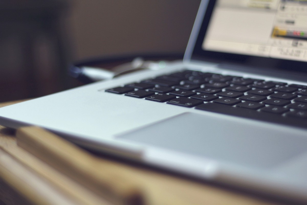 Zdjęcie przedstawia laptopa widocznego od klawiatury do połowy ekranu. Tło jest rozmyte.