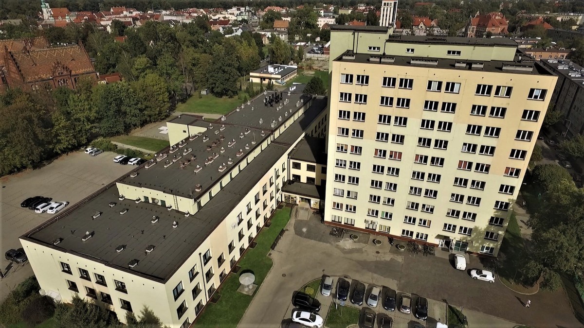Grafika przedstawia budynek pszczyńskiego spzitala widziany z lotu ptaka. Na ujeciu widać cały kompleks - pawilon łóżkowy oraz diagnostyczny.