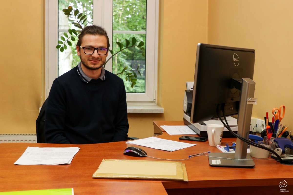 Za biurkiem w pomieszczeniu urzędu pracy siedzi Arkadiusz Niemiec. Na biurku stoi komputer i materiały biurowe.