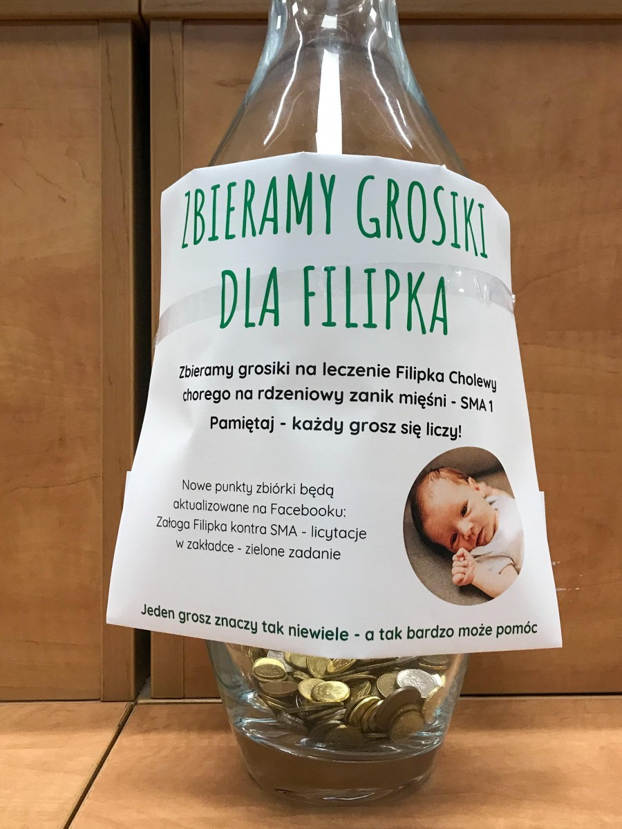Szklany wazon, do którego zbierane są grosze w ramach akcji charytatywnej.