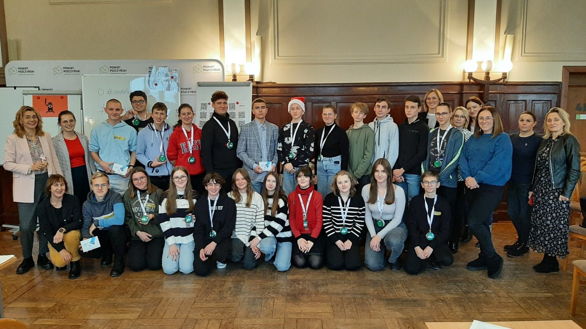 Grupowe zdjęcie uczestników projektu, którzy stoją w sali sesyjnej starostwa.