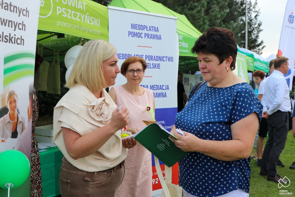 Pracownica starostwa rozmawia z kobietą. Daje jej ulotkę.
