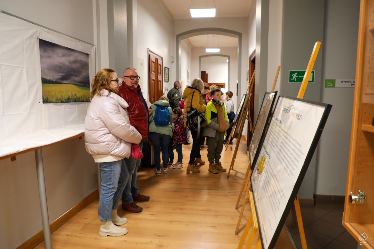 Na korytarzu starostwa przy sztalugach z elementami wystawy stoją odwiedzający