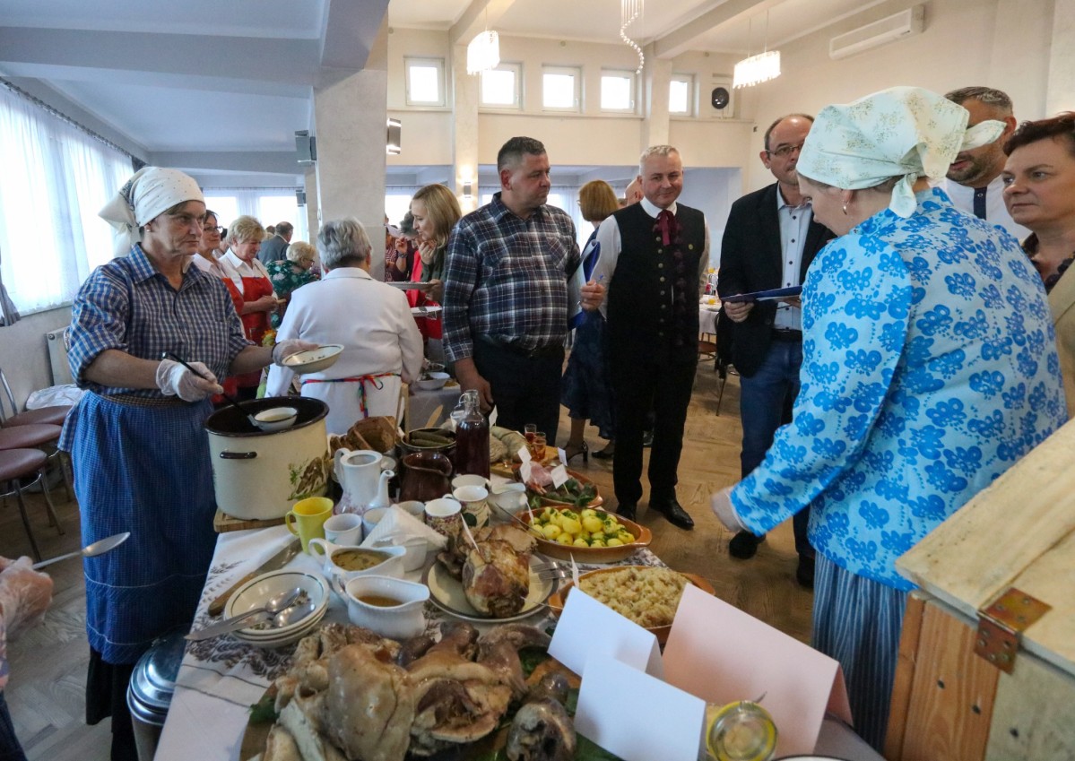 Stół z potrawami, obok gospodynie i jury.