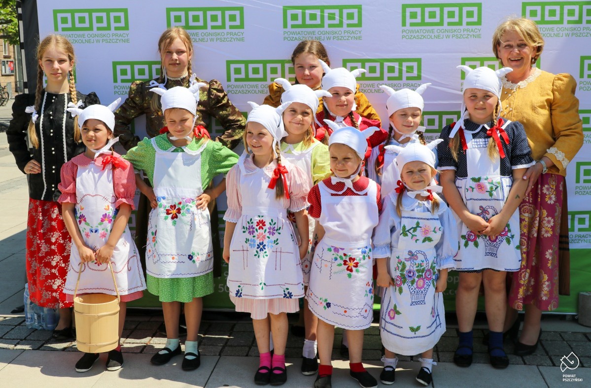 Dzieci w strojach regionalnych i czapach z różkami kóz.