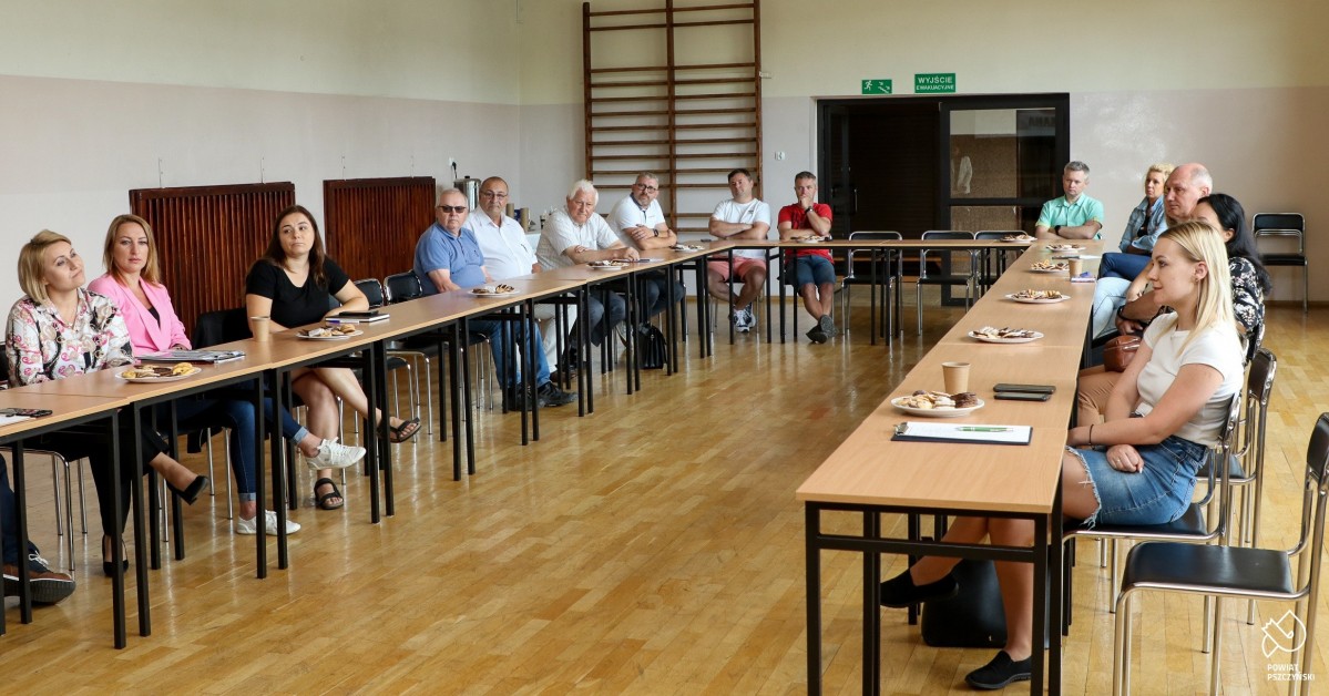 Przedsiębiorcy siedzący przy stole w sali gimnastycznej PZS nr 1 w Pszczynie.