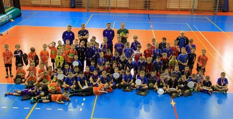Młodzi zawodnicy w strojach sportowych na płycie hali posir w pszczynie.